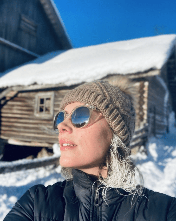 Bildet viser dame med solbriller og lue